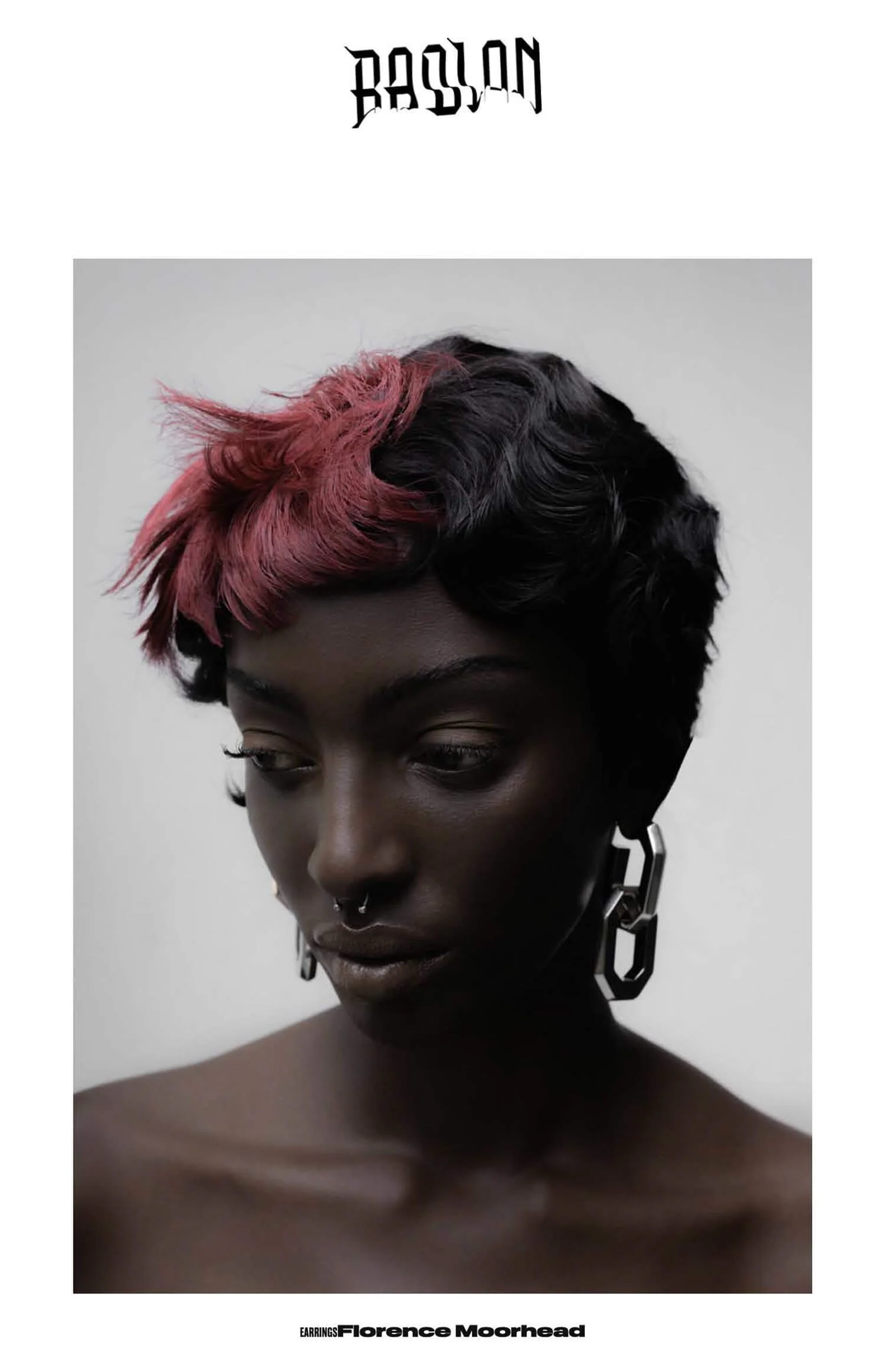 Portrait d'une femme noire aux cheveux courts, portant de grandes boucles d'oreilles en forme de chaînes