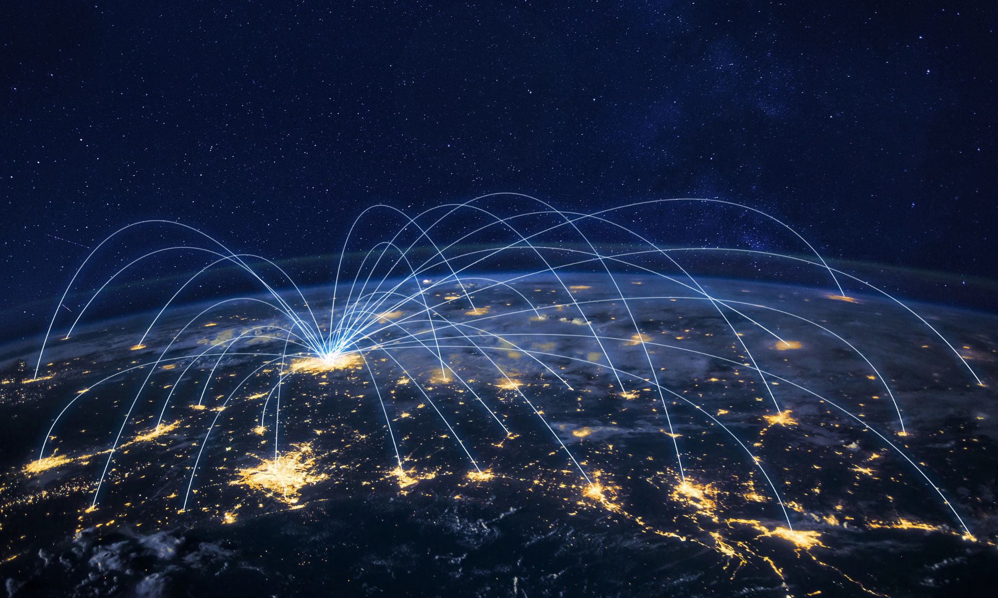 Nachtaufnahme der Erde aus dem All mit hell erleuchteten Städten und Linien, die globale Kommunikation oder Datenübertragung symbolisieren.