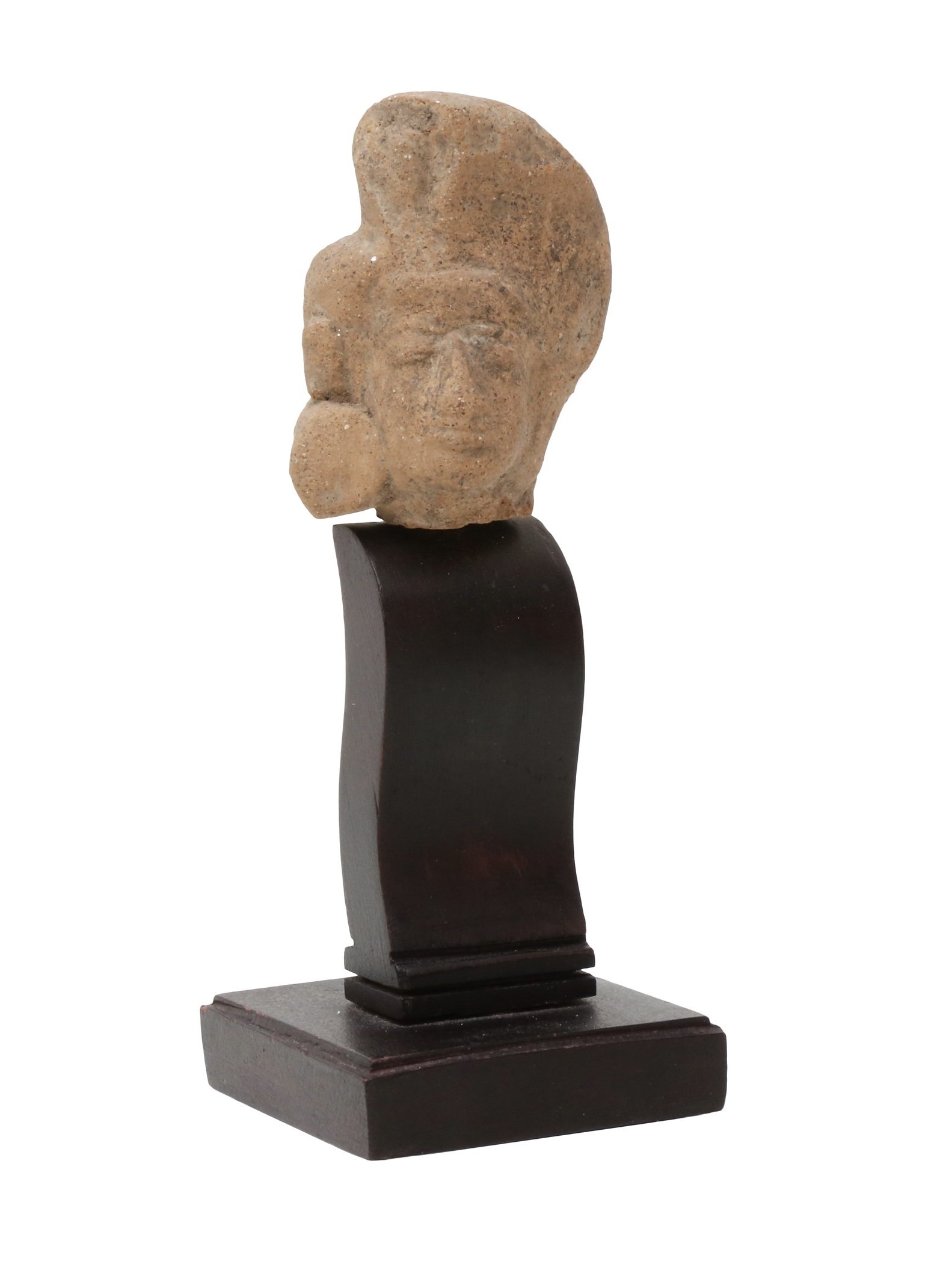 A Javanese Majapahit terracotta head with closed eyes and broad nose above pouting lips and below a voluminous coiffure. Indonesia, 14-15th century C.E.