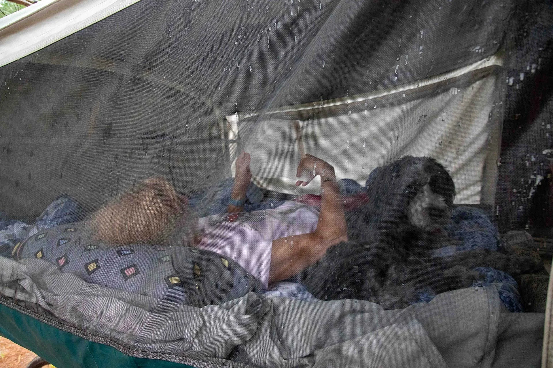 Reading inside a pop-up trailer while it's raining at an Ontario Provincial Park.