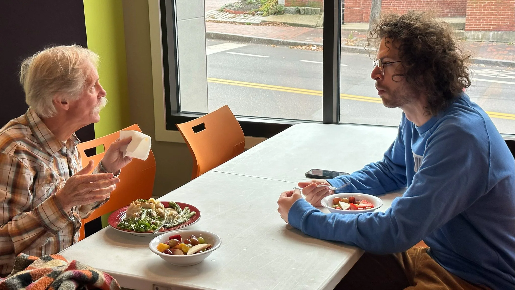Two men eating and having a conversation