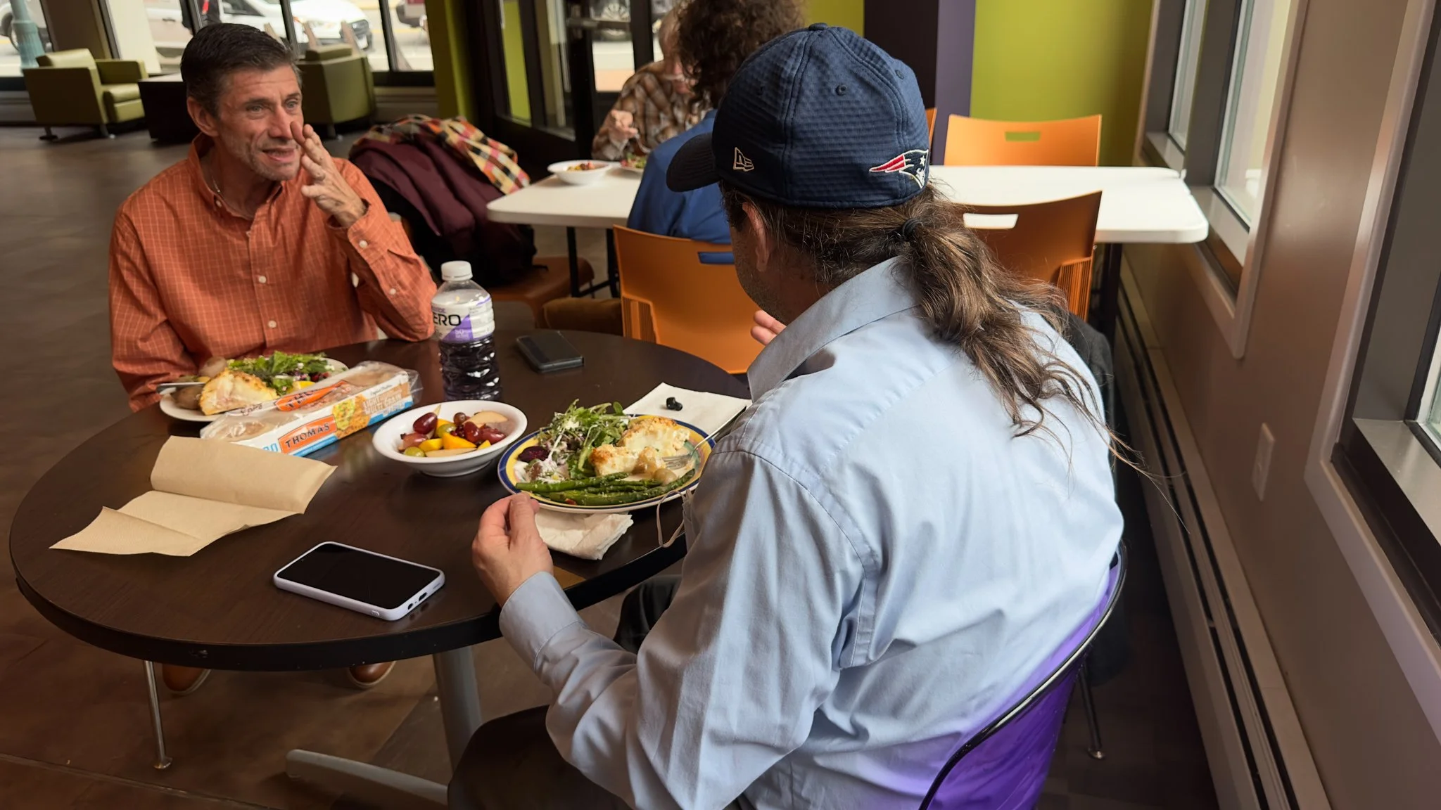 Two men having a conversation over a meal