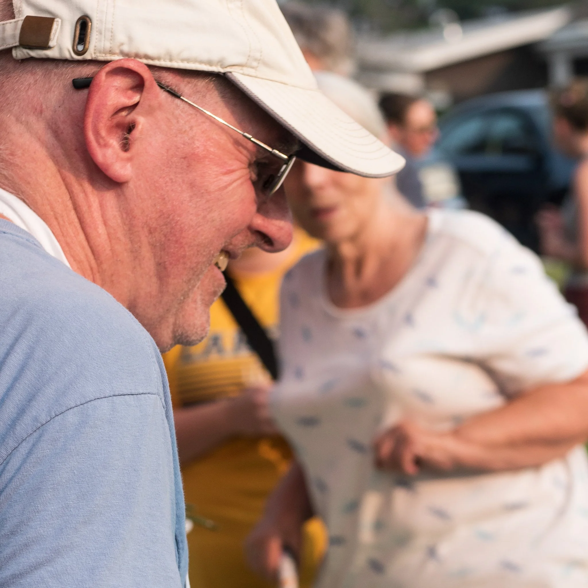 Man smiling in a hat at a picnic