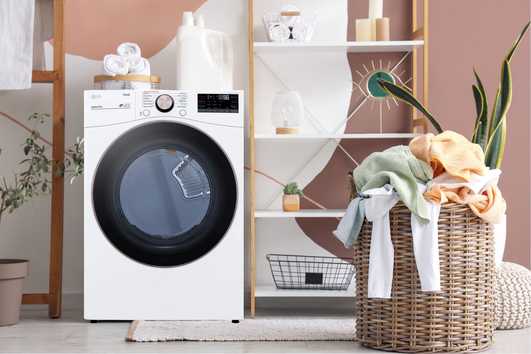 Wassenwasmachine in een wasruimte met gestapeld wit opbergrek en mand met opgevouwen handdoeken en vieze kleding.