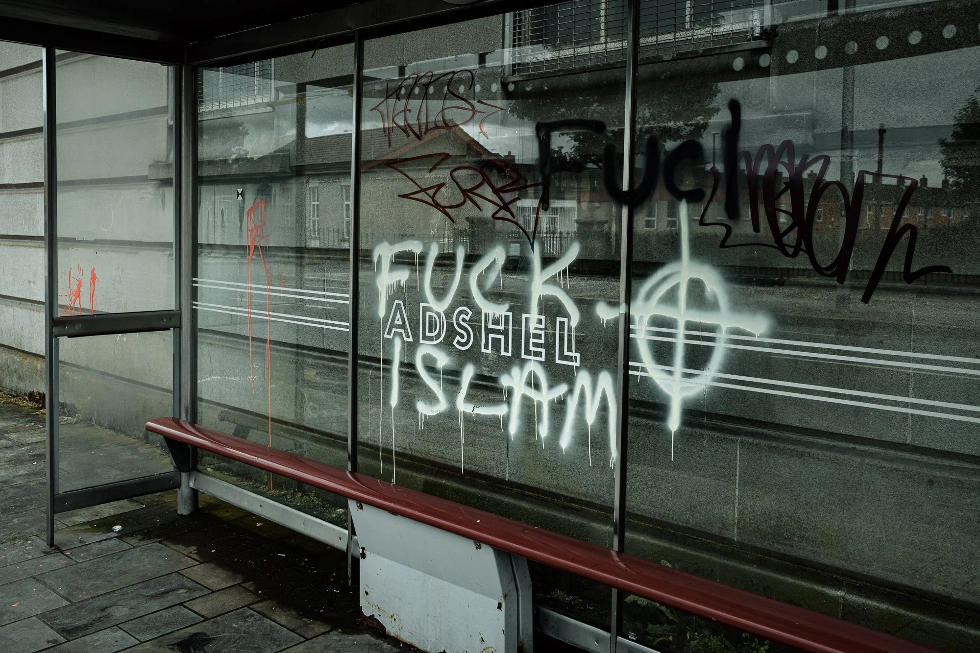 Anti-immigration graffiti on a bus shelter along the after a night of rioting. Belfast. 2026