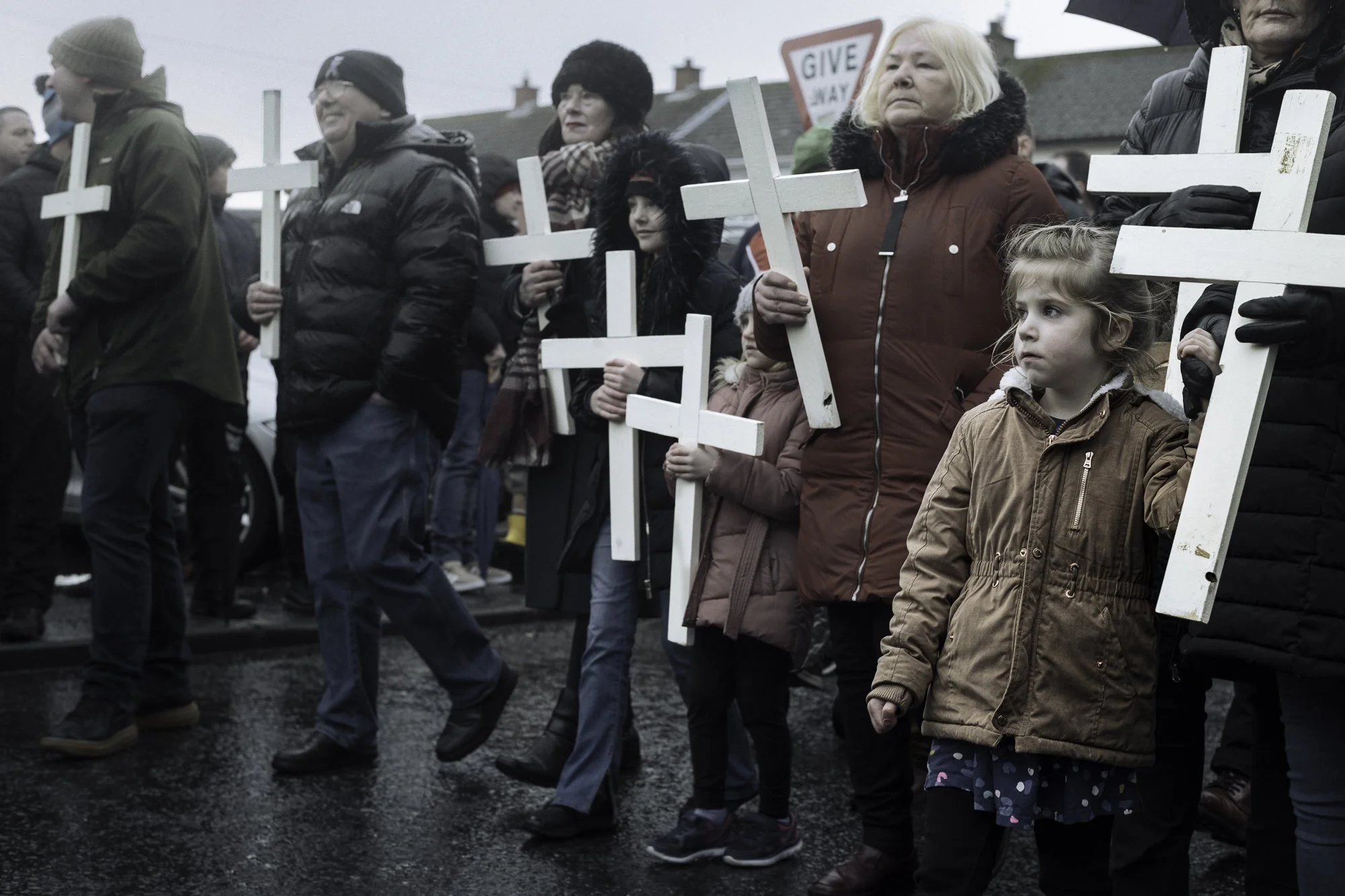 Participants carry white crosses while retracing the original 1972 civil rights march during the fiftieth anniversary commemoration of Bloody Sunday, Derry. 2022