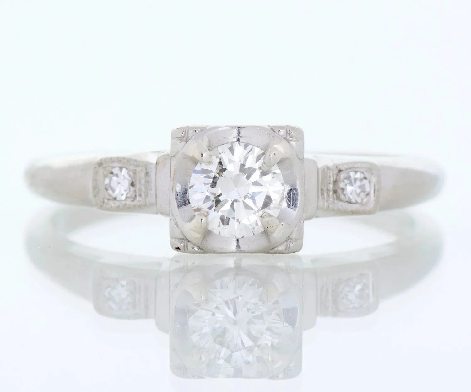 1950s mid-century engagement ring in 14k white gold with a round brilliant diamond and side diamonds