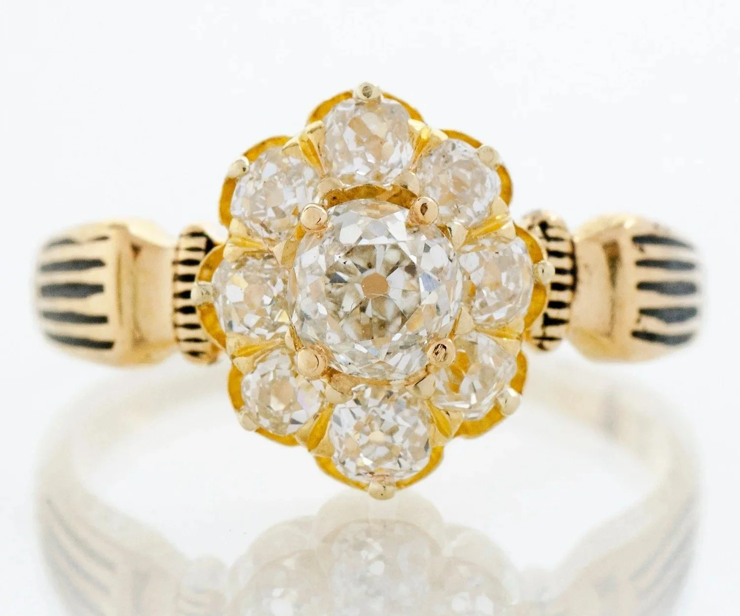 Victorian engagement ring in 14k yellow gold with a mine cut diamond flower cluster and black enamel shoulders