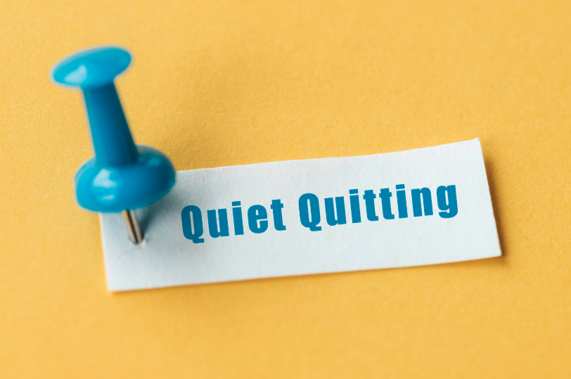 thumbtack showing note that reads quiet quitting in blue lettering