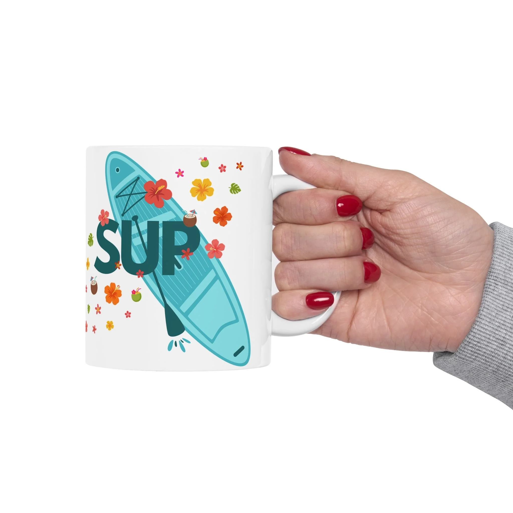 A woman holds a stand-up paddle board mug, featuring tropical colors, flowers, foliage and drinks. A great SUP gift!