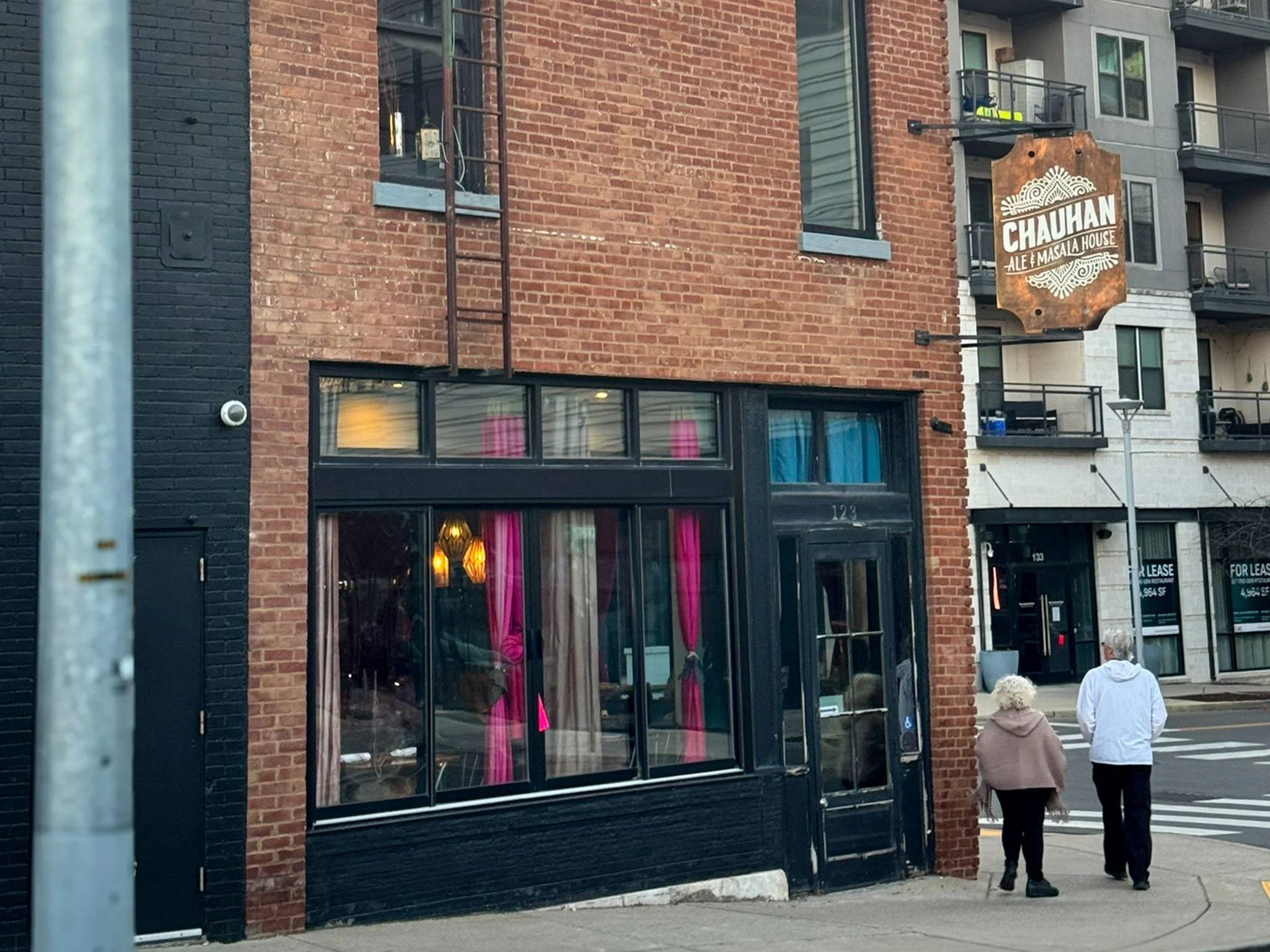 A couple walks past Chauhan Ale and Masala House, a restaurant in the Gulch neighborhood of Nashville, Tennesse.