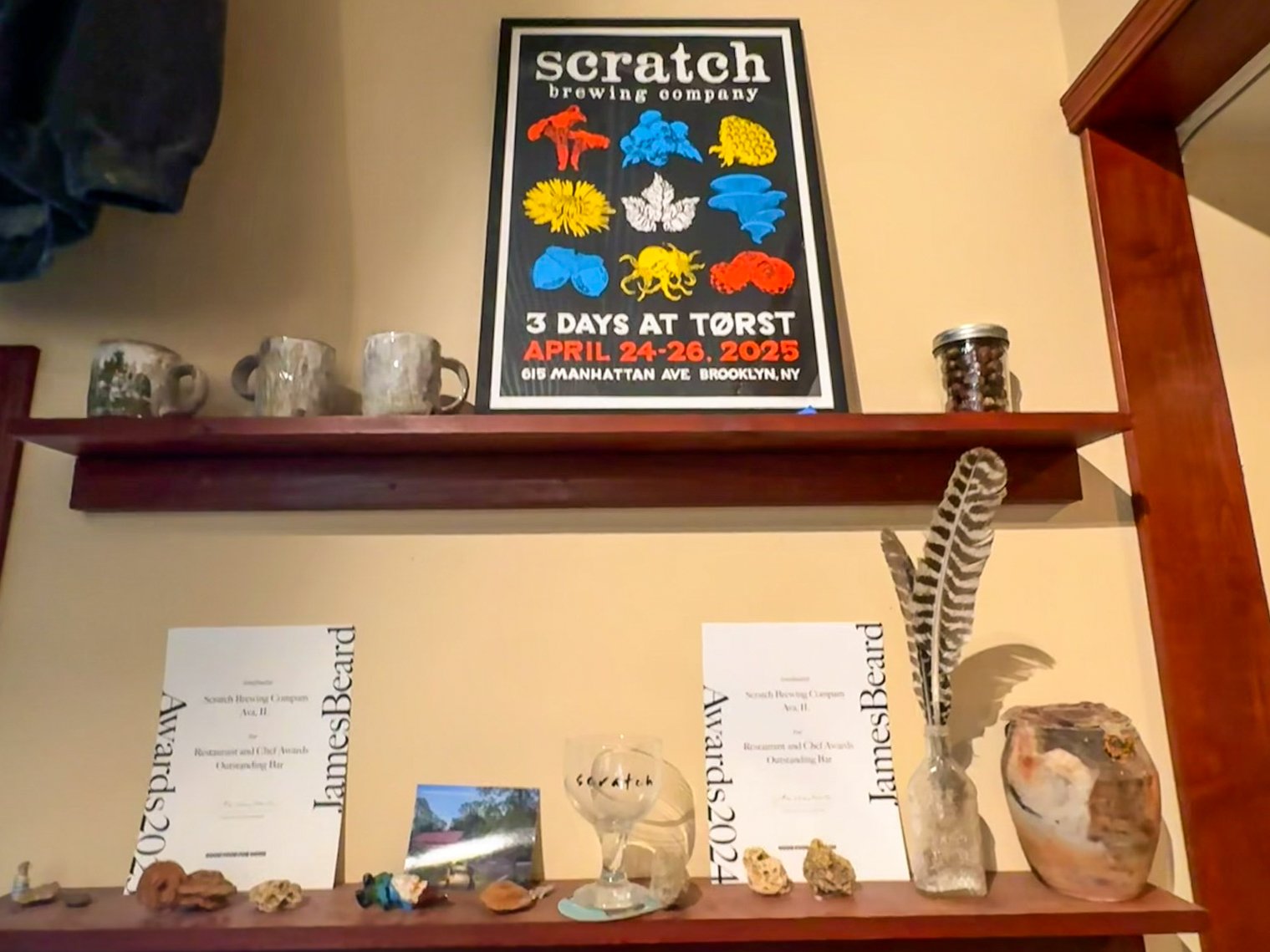 Shelf display inside Scratch Brewing featuring James Beard awards, turkey feathers, crystals and other decorative objects.