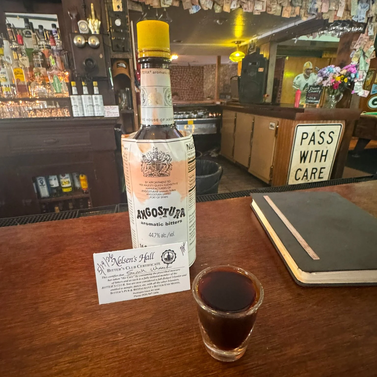 A bottle of Angostura bitters, a Bitters Club membership card and a full shot glass of the bitters sit on the bar at Nelsen’s Hall on Washington Island, Wisconsin.