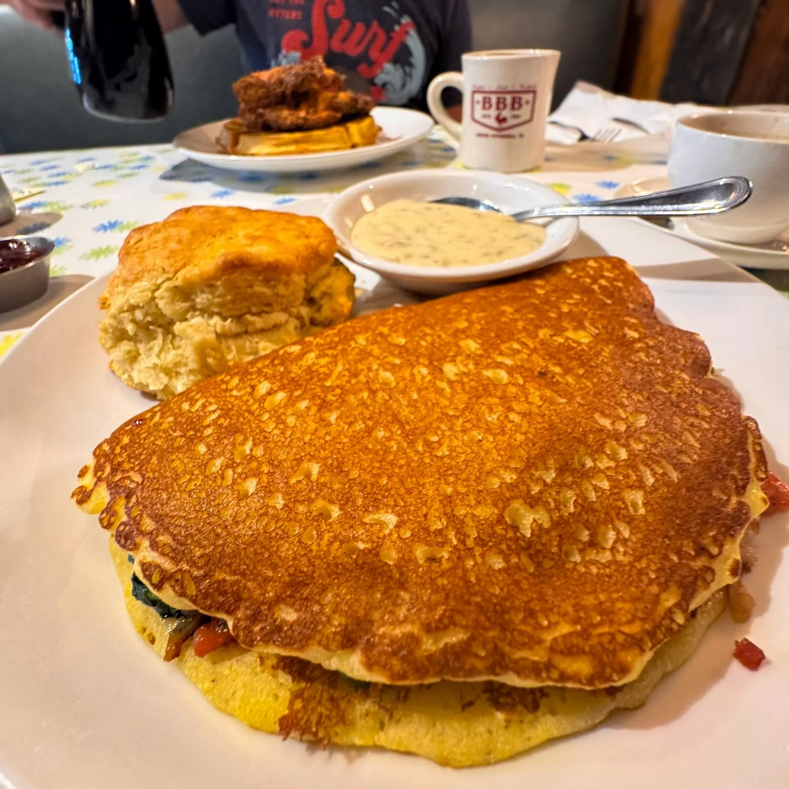 A cornbread omelet filled with bacon, spinach, tomatoes and cheese is served with a biscuit and a side of sausage gravy at Big Bad Breakfast in South Pittsburg, Tennessee.