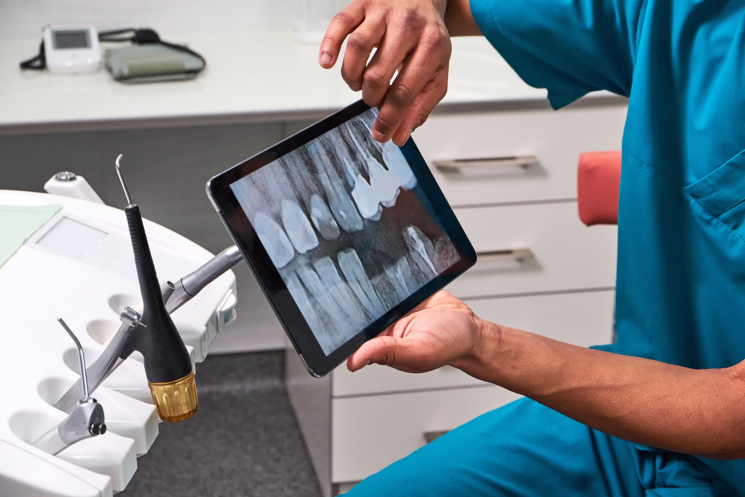 african-male-dentist-explaining-x-ray-tablet.jpg