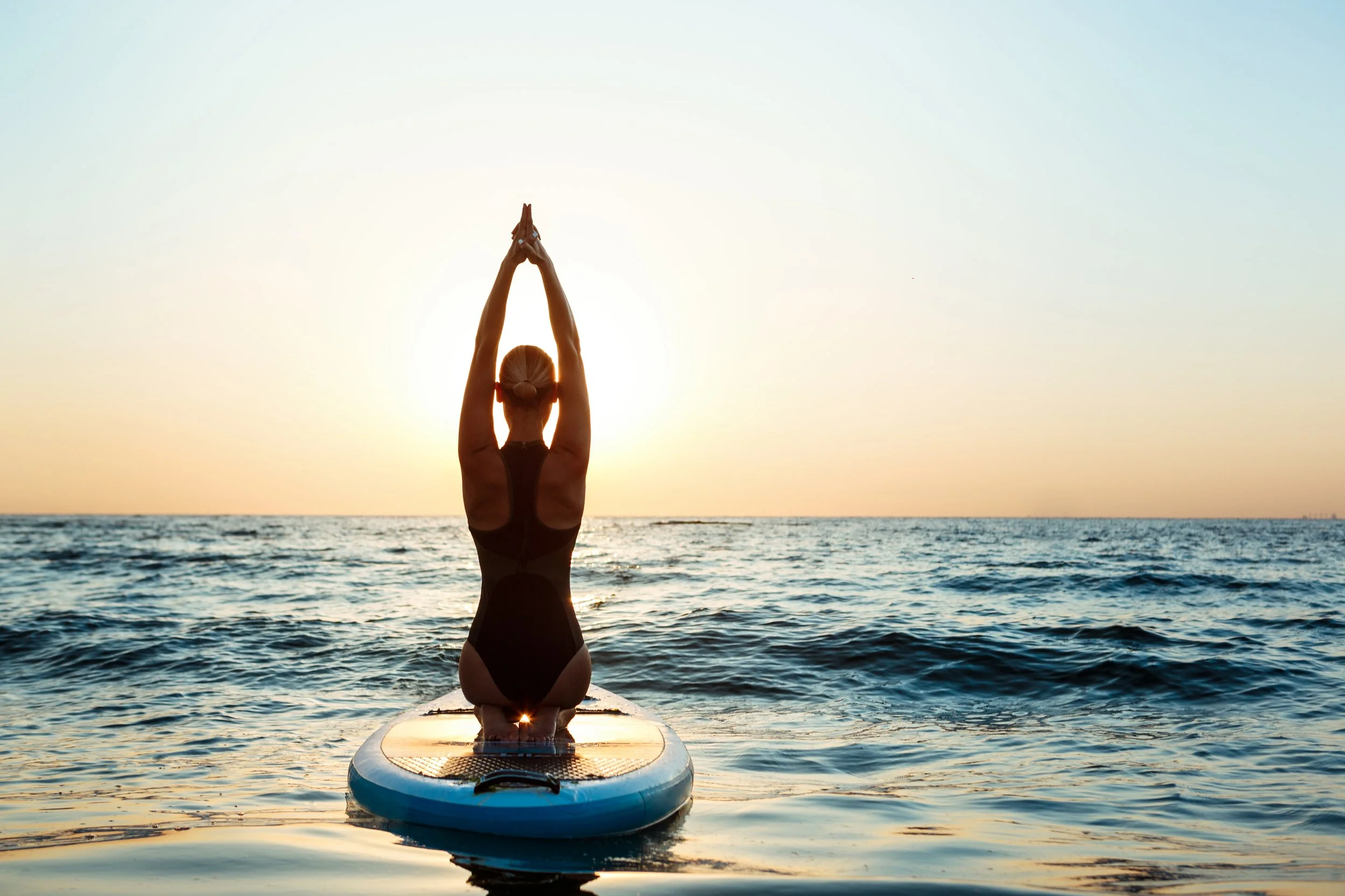 silhouette-beautiful-woman-practicing-yoga-surfboard-sunrise.jpg