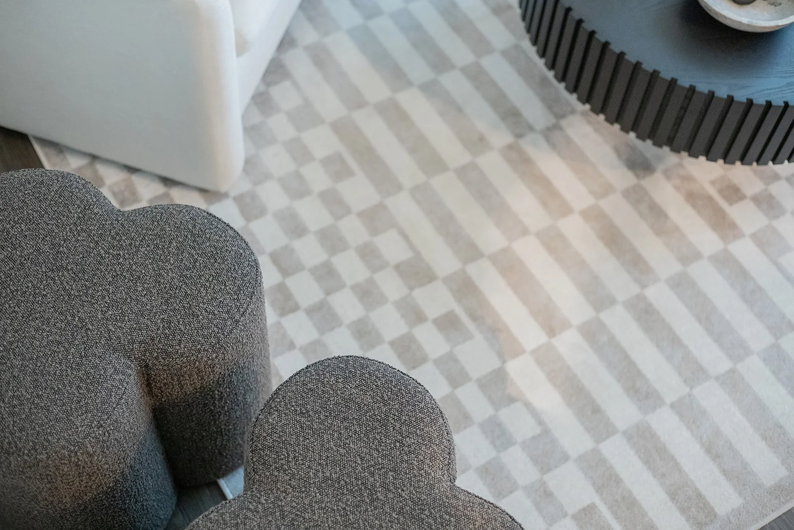 Close up, detail photo of neutral living room rug and ottomans.