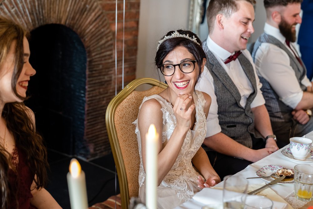 bride laughs during speeches at Cavendish house
