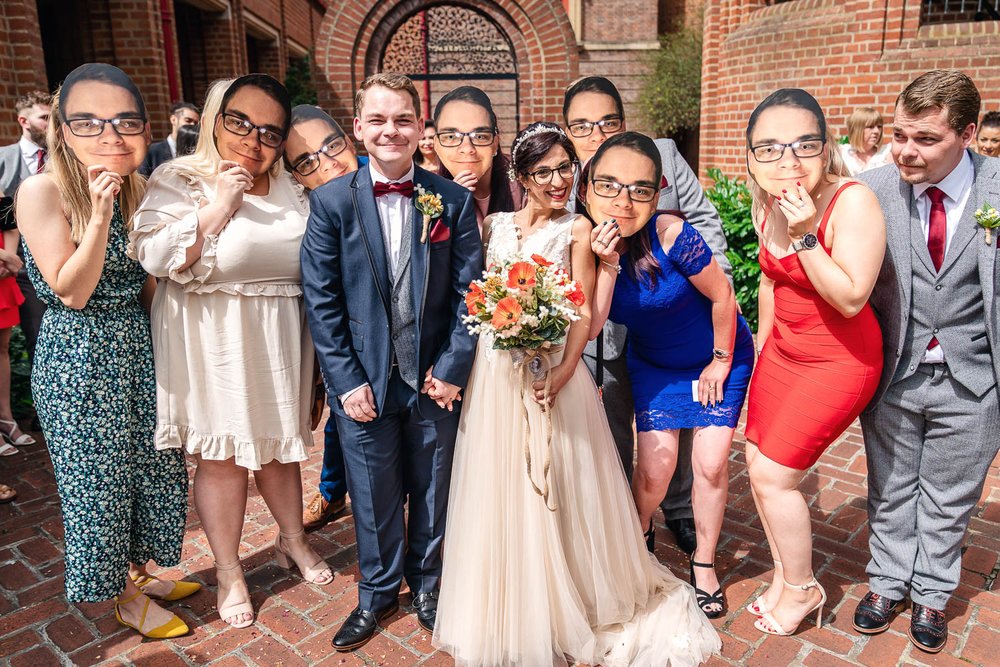 wedding guests with masks of the grooms face