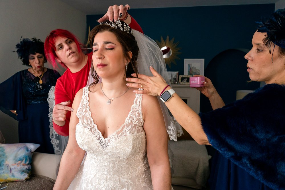 Portuguese bride has her wedding veil attached