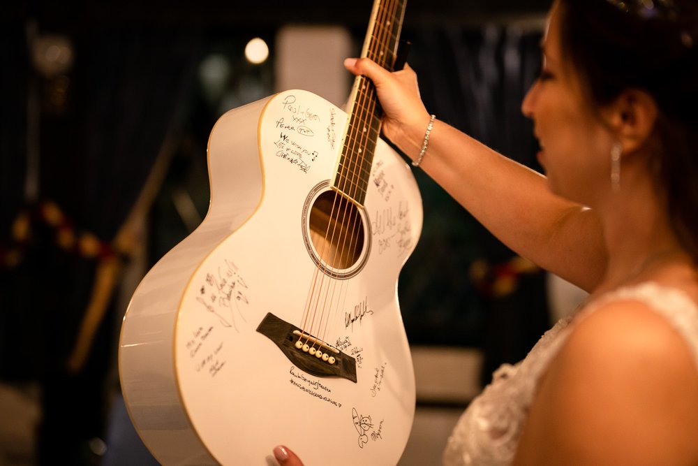 White acoustic guitar signed by wedding guests