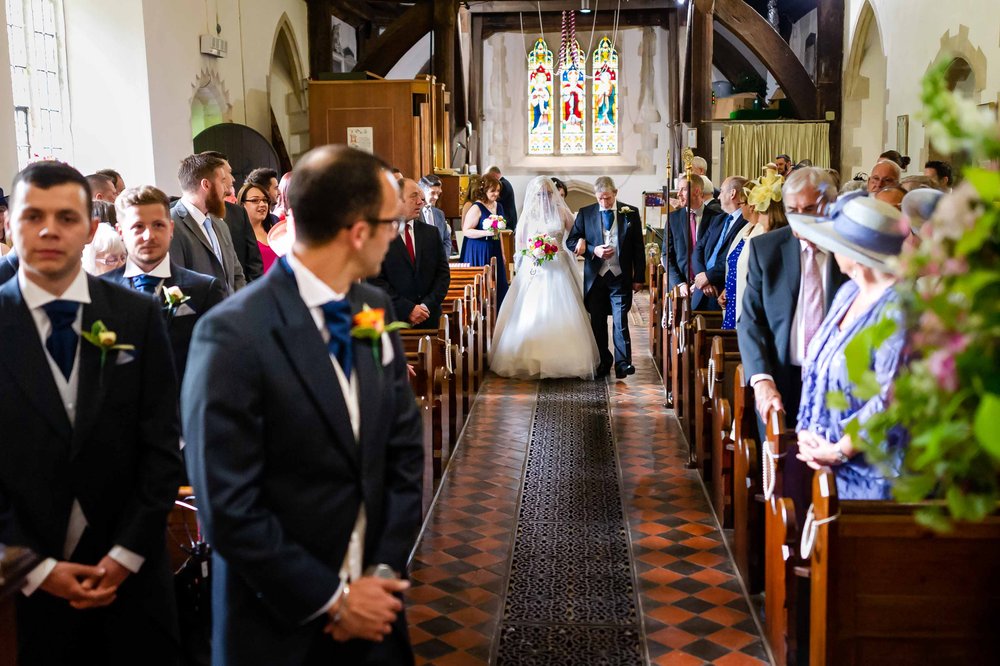 Groom turns to watch his bride coming up the aisle at a Hampshire wedding