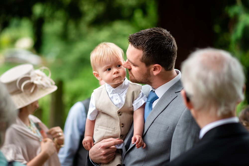 A father carries his son at a Hampshire wedding