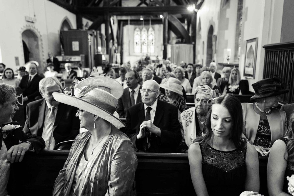 Guests await the bride and groom at a village church wedding in Hampshire