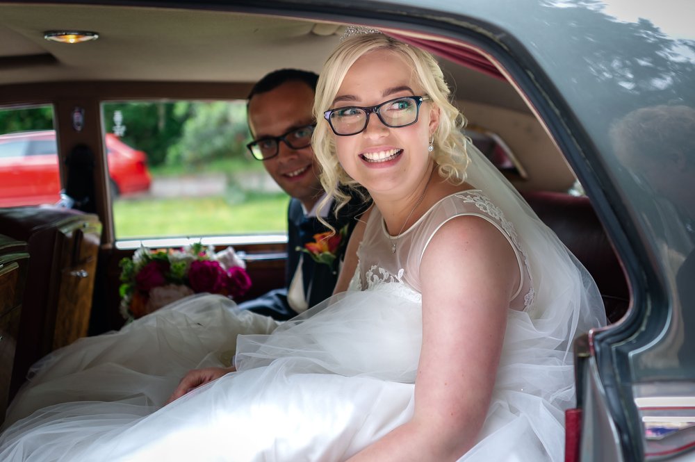 Bride and groom in the back of their wedding car at Warbrook House