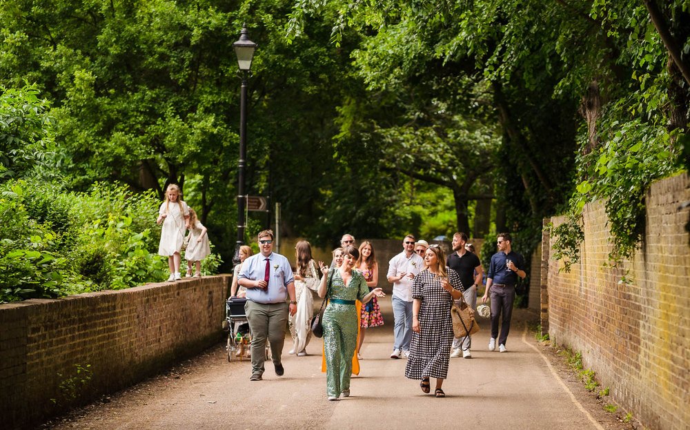 Wedding guests walk along Thames Path