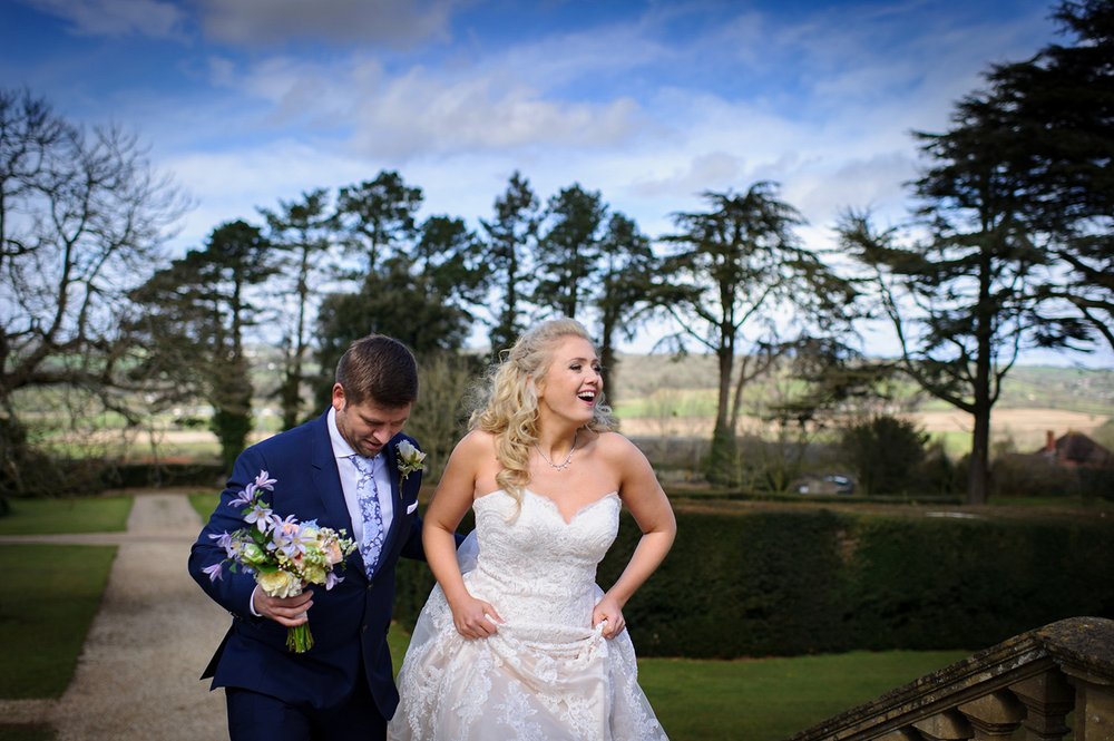 Bride and Groom walk up the steps of Coombe Lodge