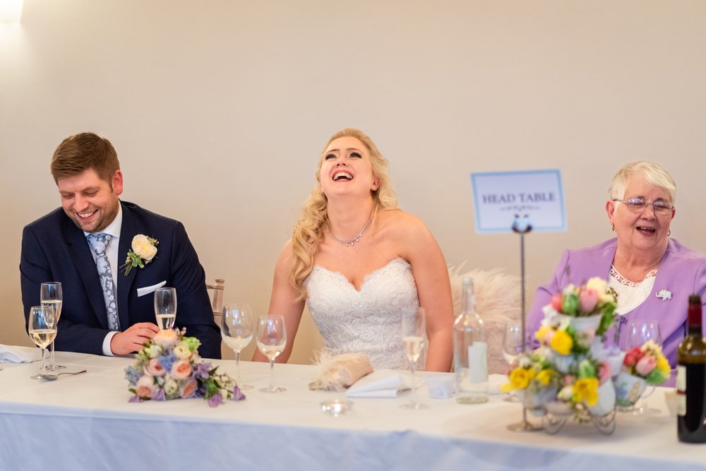 Bride laughs at speech during Coombe Lodge wedding