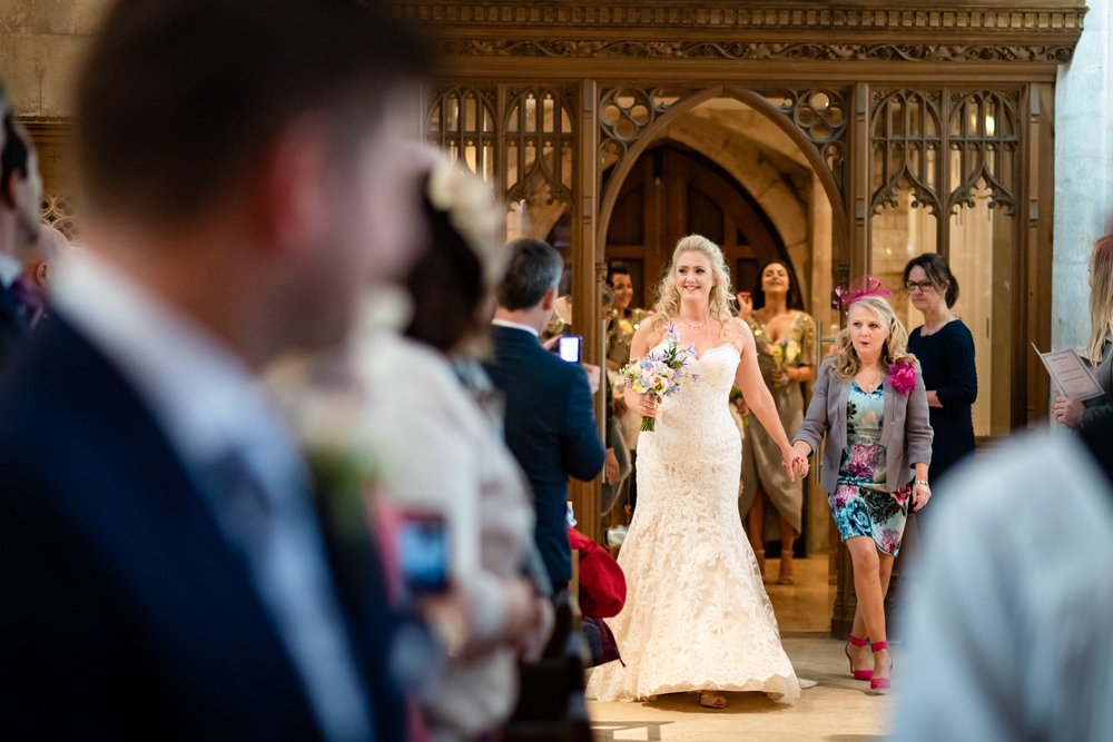 Bride walks down the aisle of St Andrews Church, Blagdon