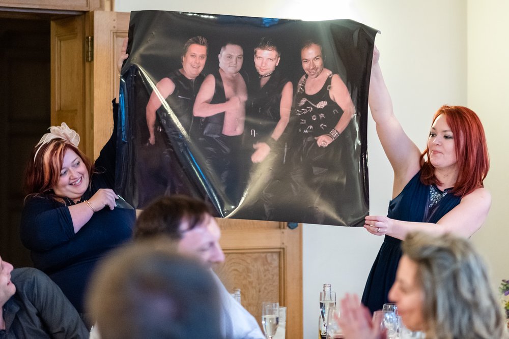 Guests hold aloft a comedy poster during best mans speech