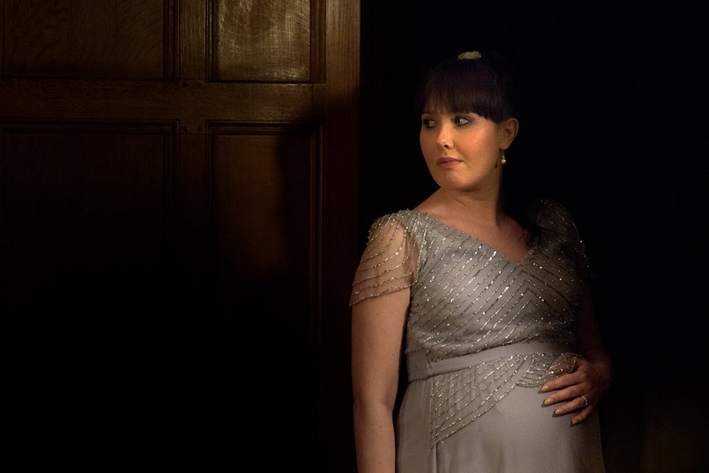 Pregnant bridesmaid holds her bump at Coombe Lodge wedding