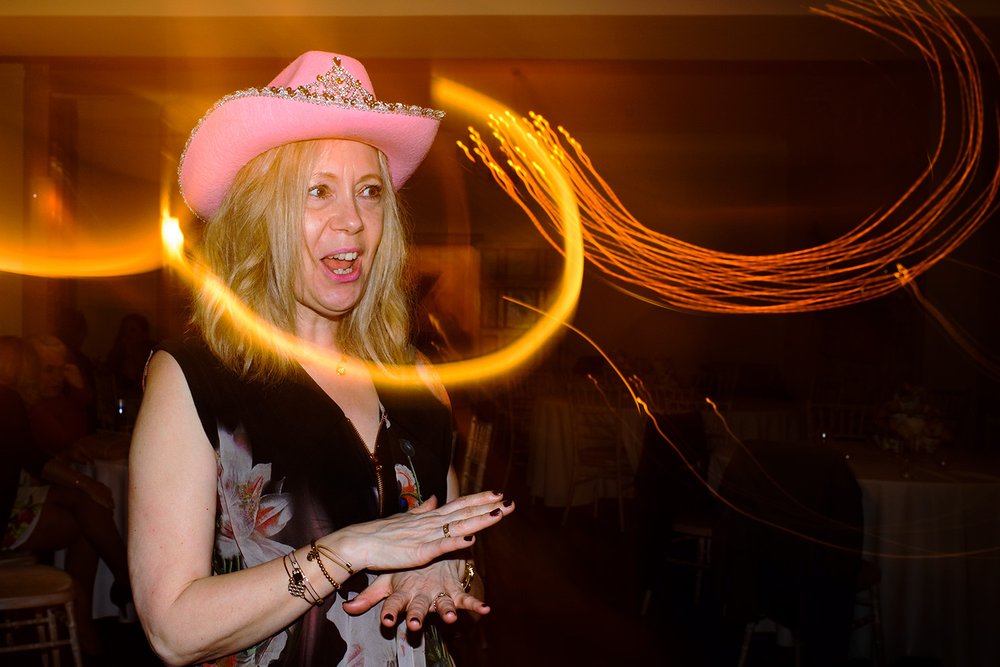 Woman dances in a pink cowboy hat at Coombe Lodge