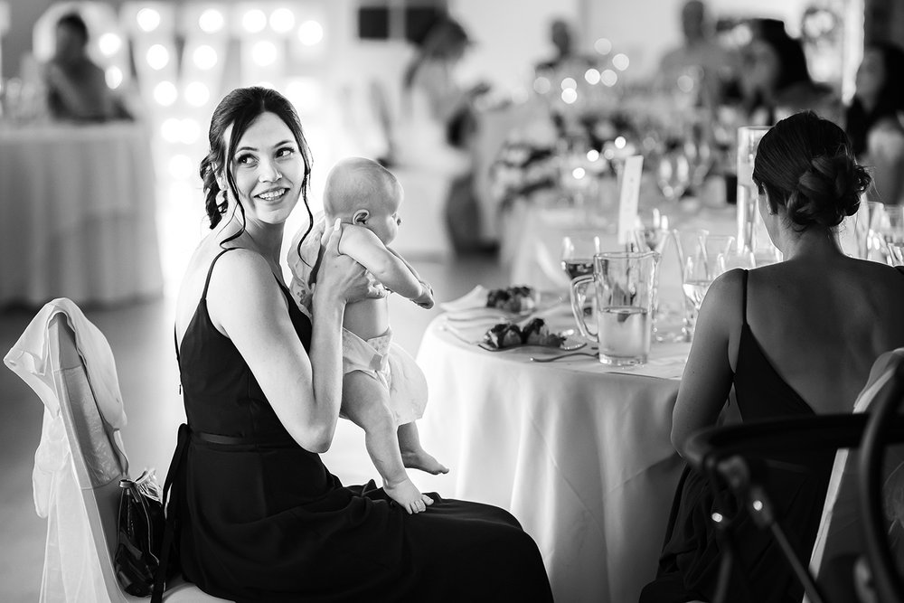 Bridesmaid holds baby at an Essex wedding