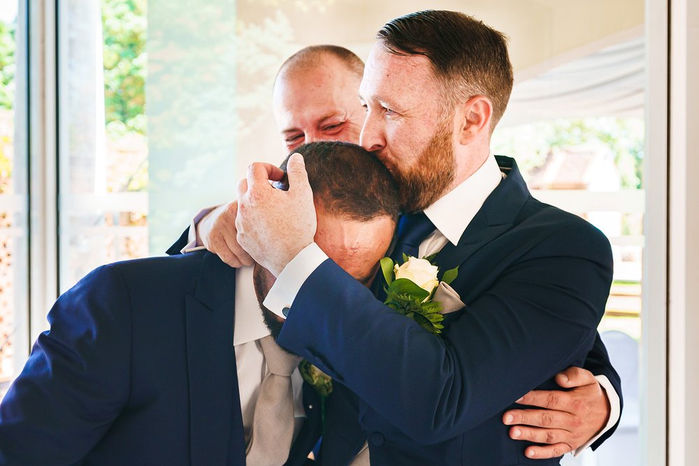 Groom hugs his emotional best man before Friern Manor wedding