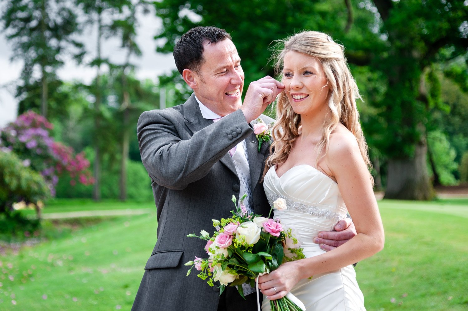 Groom removes stray hair from brides face, Donnington Valley Hotel, Newbury 