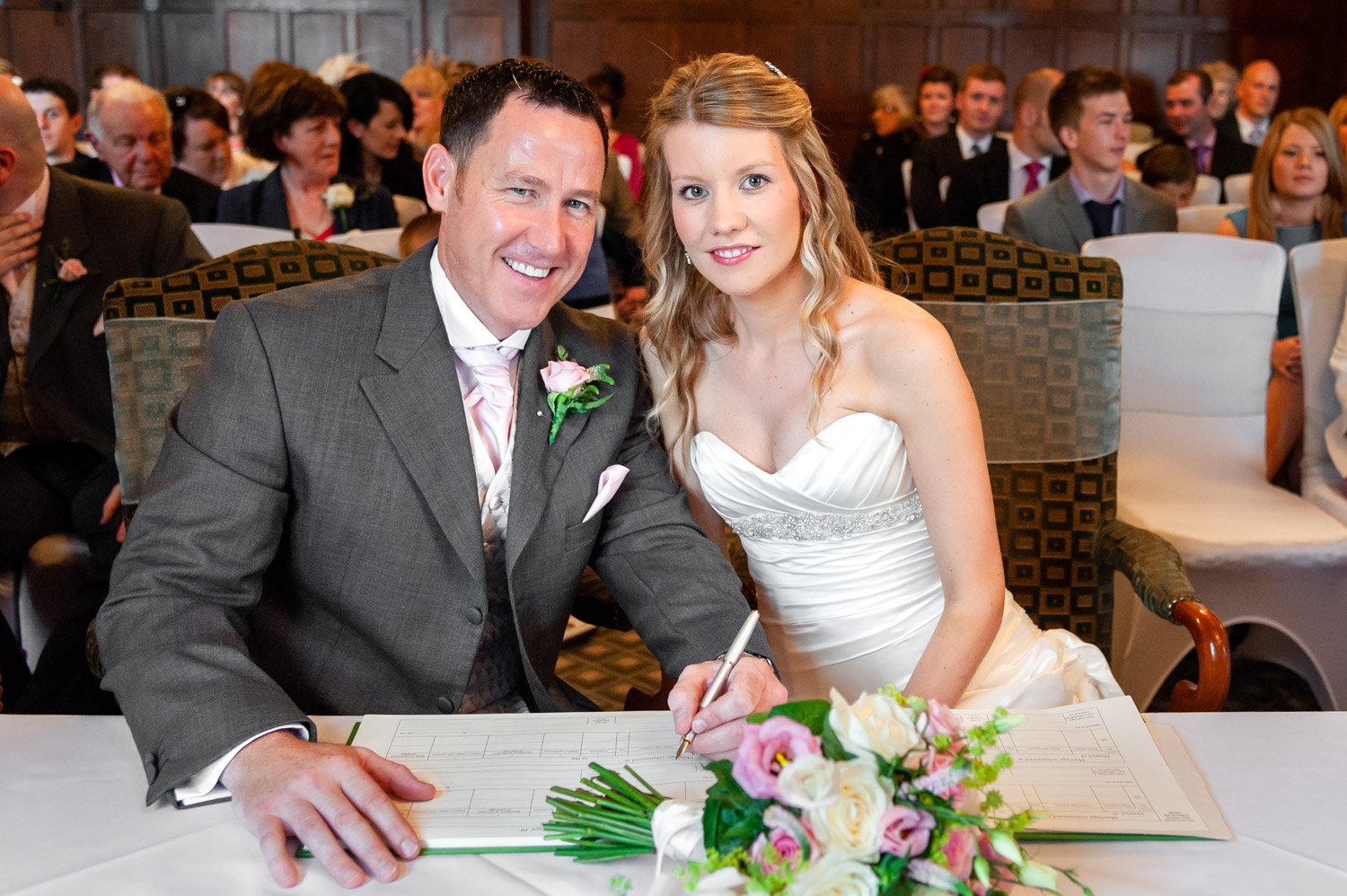 Newlyweds sign register at Donnington Valley Hotel, Newbury