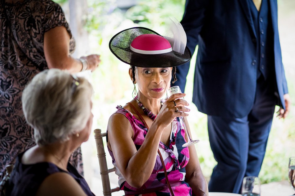Female guest in a fashionable hat at summer wedding at The 