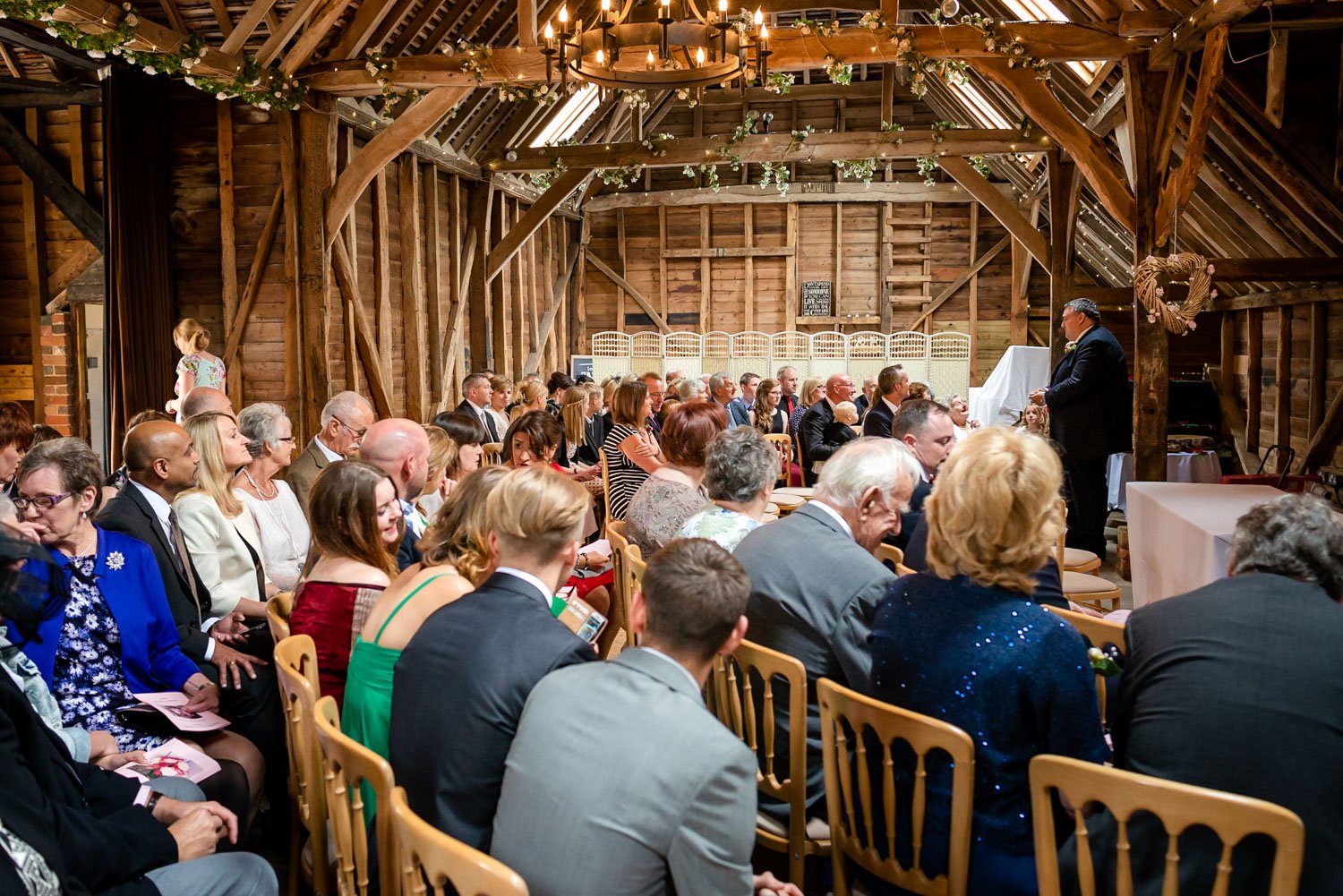 Wedding guests wait the start of a barn wedding in Berkshire