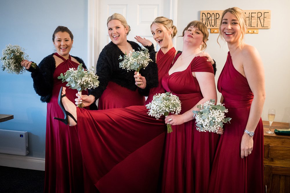 bridesmaids laughing in burgundy dresses