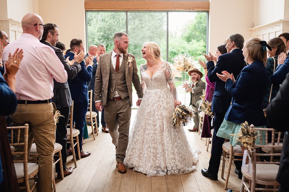 Newlyweds leave the ceremony at Millbridge Court