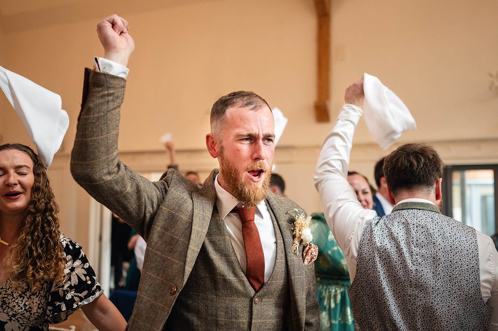 Groom enters the wedding breakfast at Millbridge Court