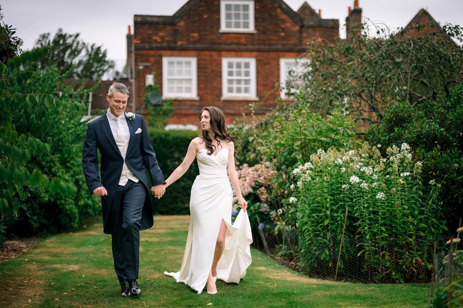 Newlyweds walk in the grounds of Hutton Hall wedding venue in in Essex