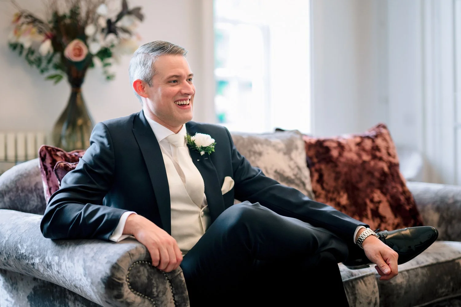 A groom relaxes at Hutton Hall before his Essex wedding