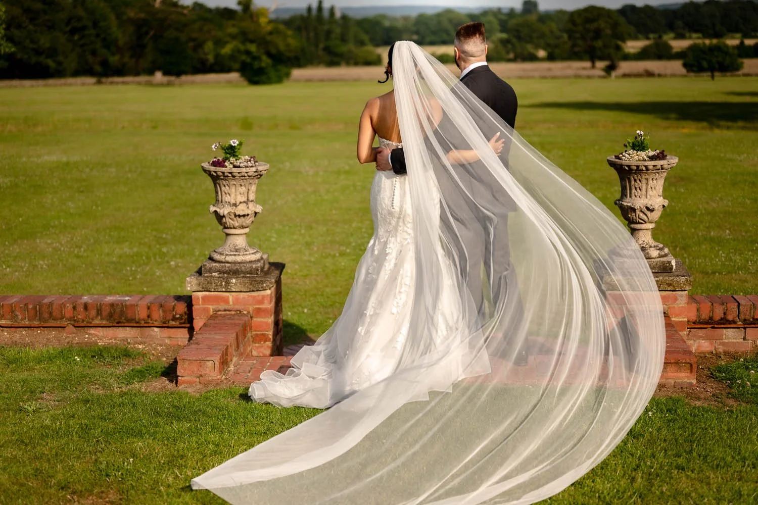 A bride and groom look out onto the grounds of Micklefield Hall in Rickmansworth. Steve Bagness Photography
