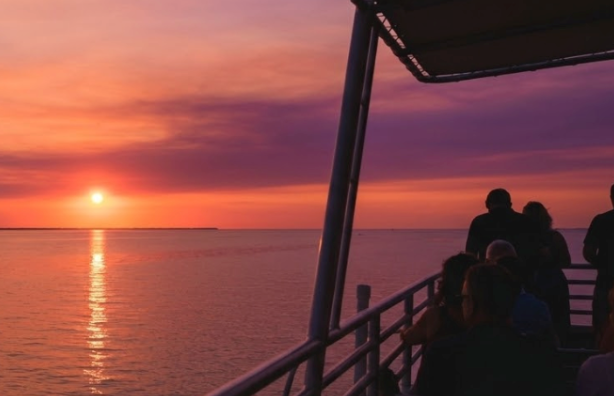 Brilliant orange pink sunset over the Gulf of Mexico viewed from a private boat deck Panama City Beach Florida