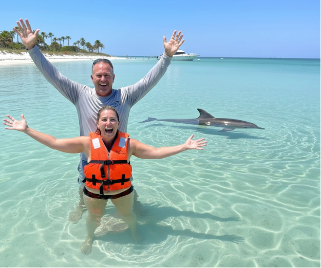 Beginner swimmer with life jacket meeting dolphins PCB